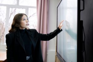 Enseignante utilisant un tableau numérique dans une salle de classe.
